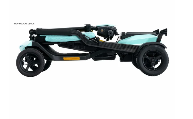 A side profile view of a compact electric three-wheeled vehicle, also known as a micro EV or folding electric wheelchair, in black and light turquoise/mint. The image is set against a plain white background with a small text label in the upper left reading 'NON-MEDICAL DVIDE' (which appears to be a typo for 'DEVICE').