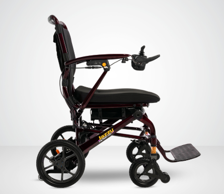 A dark red and black electric wheelchair shown from a side profile view against a light gray studio background. The brand name 'JAZZI' is visible on the frame.
