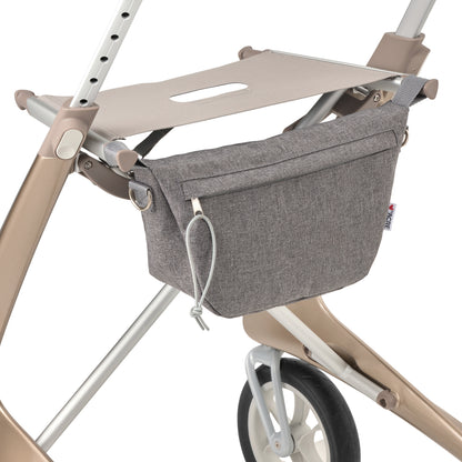 Gray rollator organizer attached to a beige rollator on a white background
