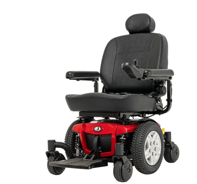 A power wheelchair with a black padded seat, black armrests, and a red body shell, shown from a three-quarter angle on a white background.