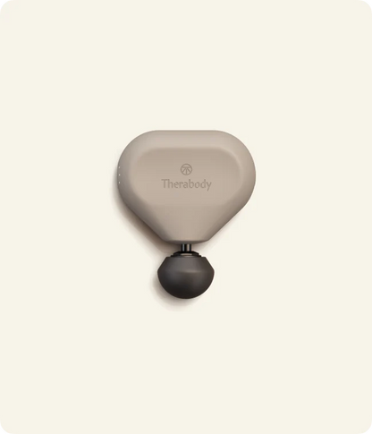 Theragun Mini 3.0 portable percussion massage gun in oat color designed for compact muscle recovery and on-the-go tension relief.