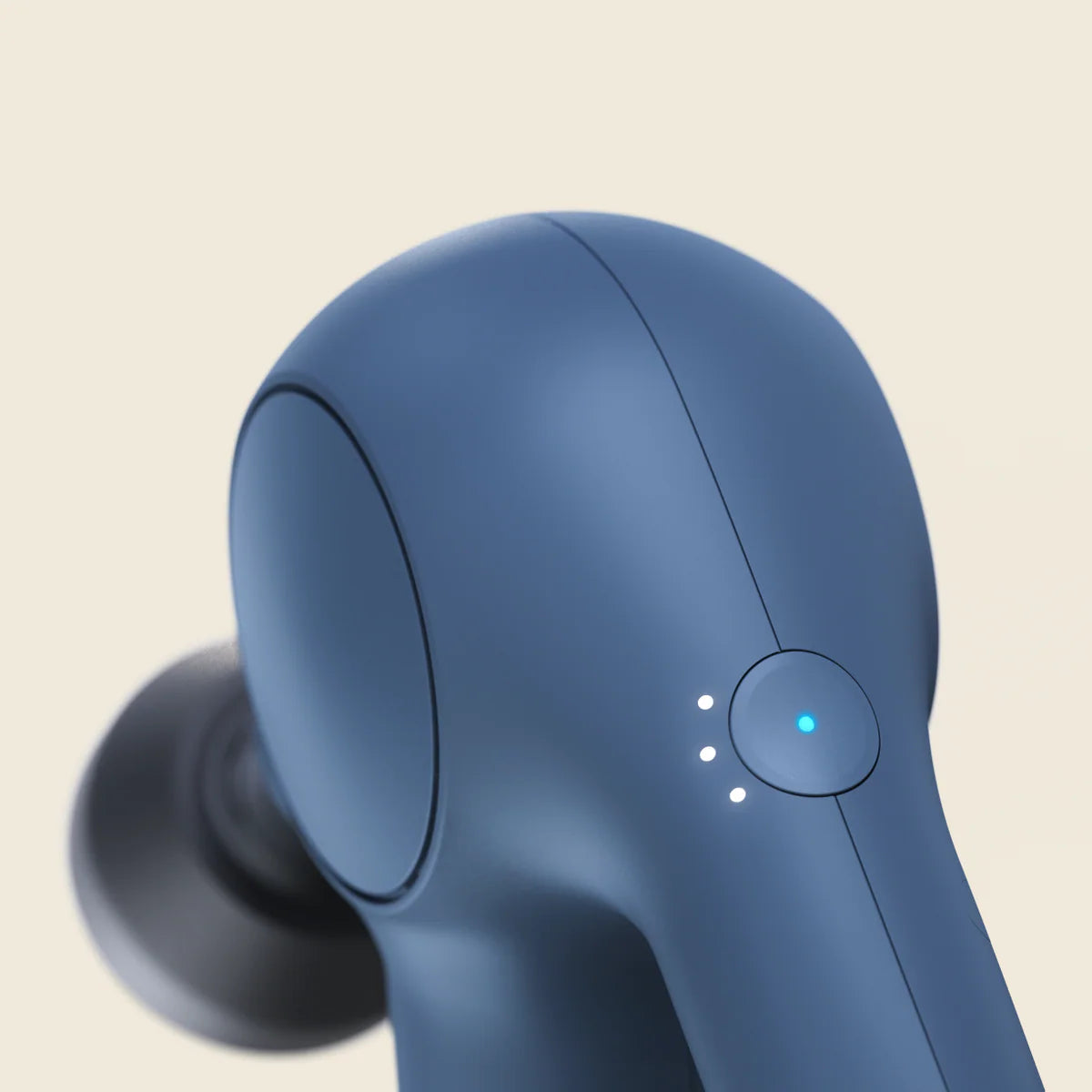 Close-up view of the navy Theragun Relief percussion massage gun showing ergonomic design and power indicator lights.