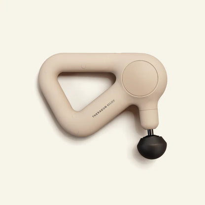 Theragun Relief percussion massage gun in sand color designed for muscle recovery, tension relief, and everyday wellness support.