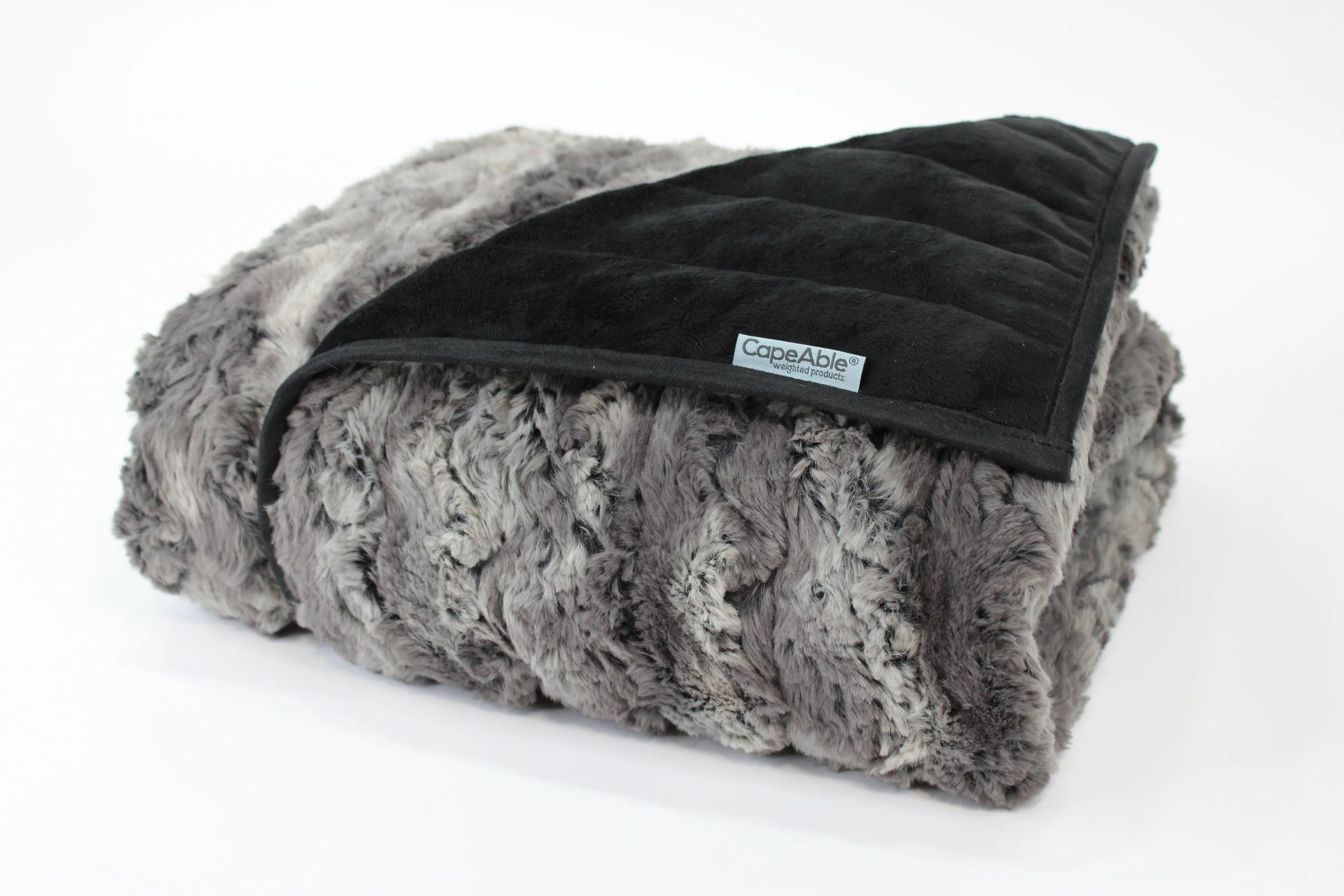 Folded CapeAble weighted blanket in tranquility gray swirl faux fur exterior with quilted black interior lining, displayed on white background