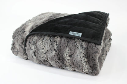Folded CapeAble weighted blanket in tranquility gray swirl faux fur exterior with quilted black interior lining, displayed on white background