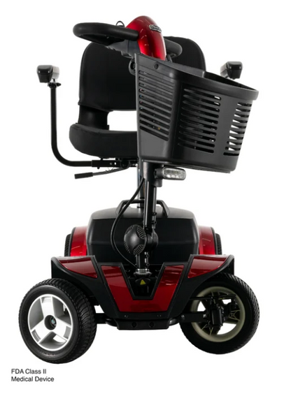 A red and black FDA Class II medical power wheelchair with a large black front basket, shown from a three-quarter rear angle on a white background.