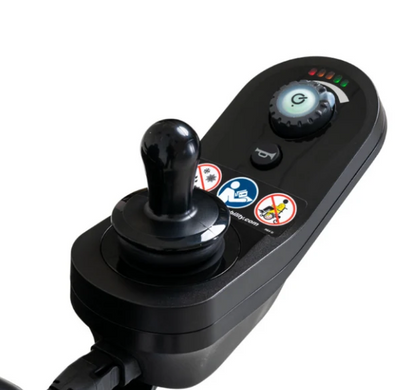 A close-up of a black joystick control module with a central joystick, a rotary dial, small buttons, and several printed warning and instruction icons on a white background.