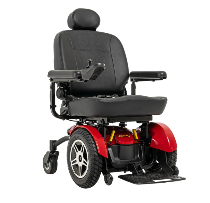 A power wheelchair with a black upholstered seat and armrests, red plastic body panels, and black wheels, shown on a plain white background.