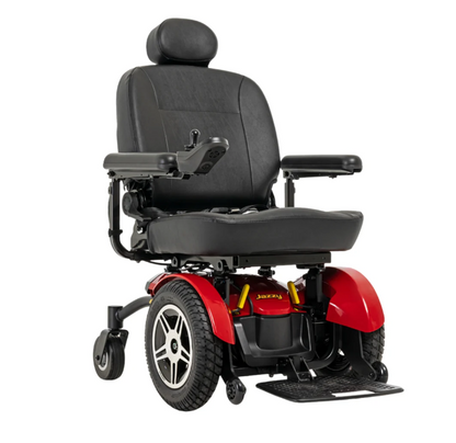 A power wheelchair with a black upholstered seat and armrests, red plastic body panels, and black wheels, shown on a plain white background.