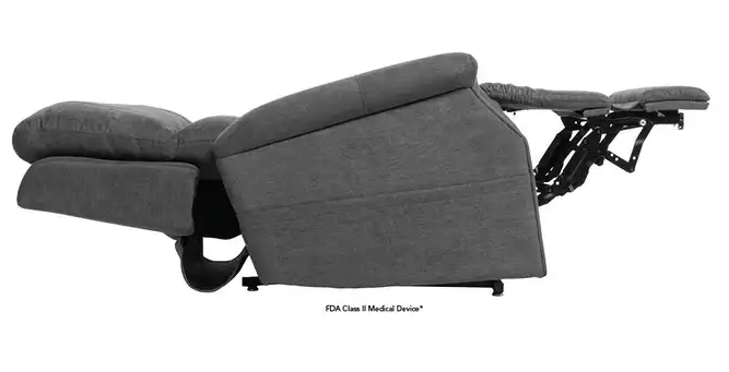 A dark gray fabric recliner chair shown in a side profile with the footrest extended, on a plain white background. Small text below reads 'FDA Class II Medical Device'.