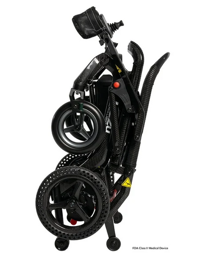 A folded black carbon-fiber electric wheelchair shown on a plain white background, with its large rear wheels, handlebars, and control panel visible.