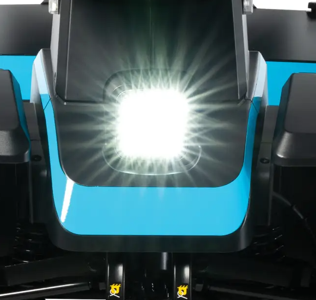 Close-up of a bright white LED work light mounted on a black and cyan industrial machine housing.
