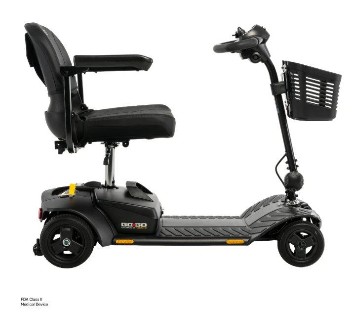 A black Segway-style mobility scooter with a high backrest seat, armrests, handlebar, front basket, and four wheels, shown in side profile on a white background. Small text in the lower left reads 'FKA Class 6 Medical Device'.