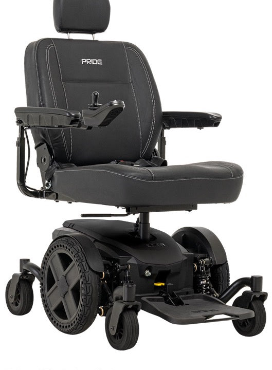 A black electric power wheelchair with a padded seat, headrest, armrests, and large rear wheels, photographed on a clean white background. The backrest shows the brand name PRIDE.