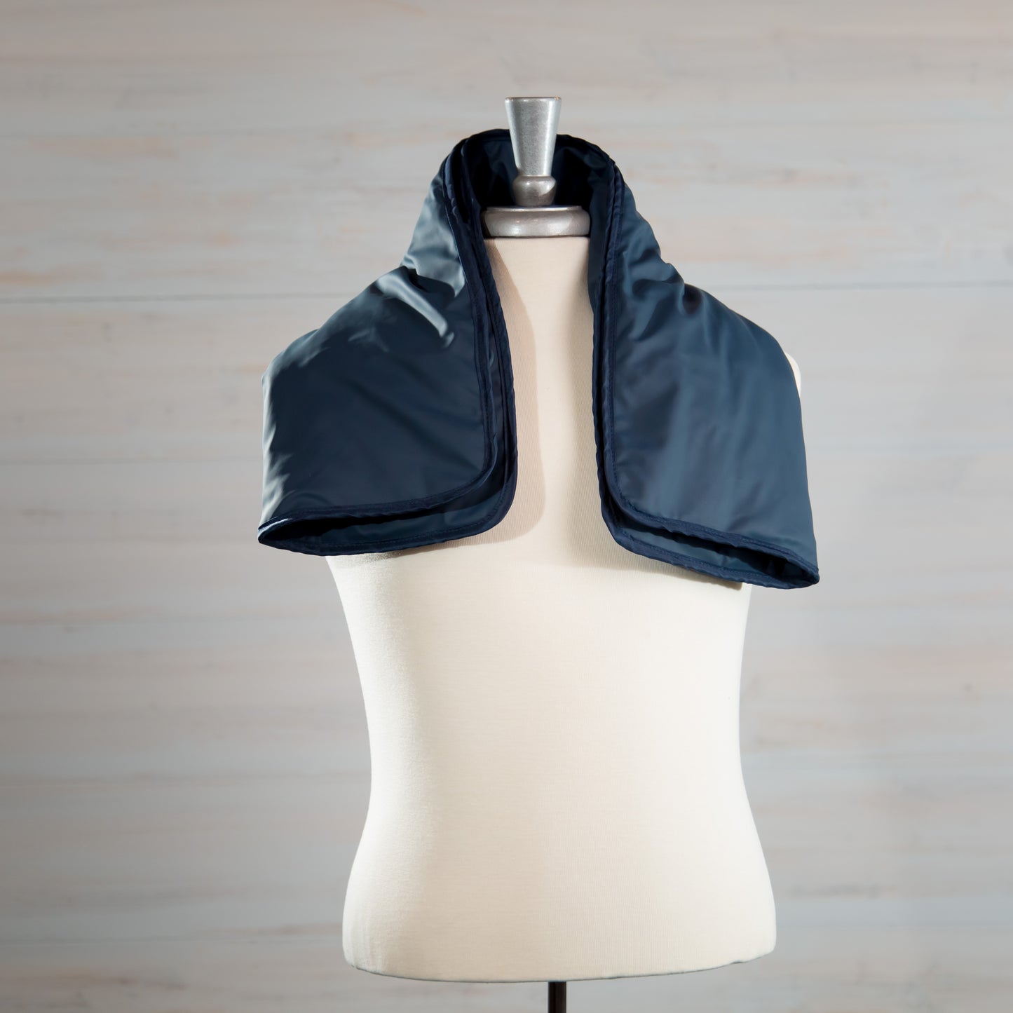 Navy medical-grade weighted lap pad displayed on a mannequin.