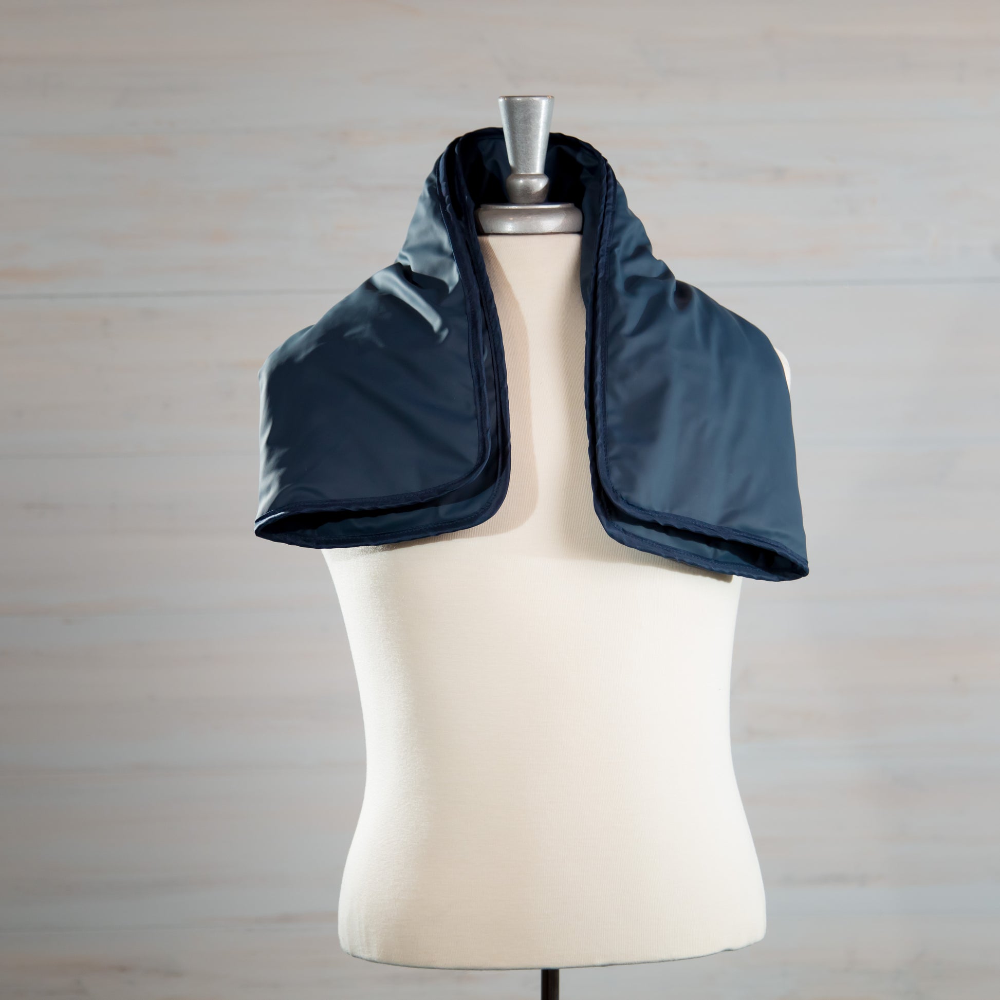 Navy medical-grade weighted lap pad displayed on a mannequin.